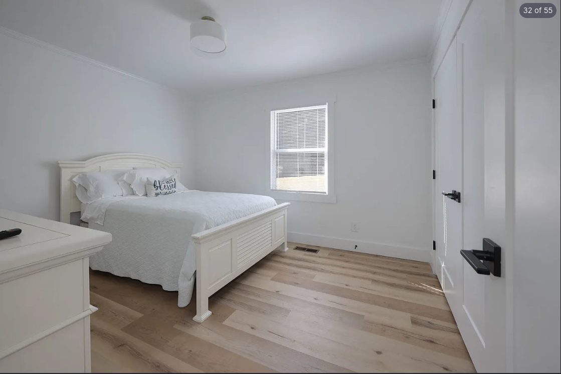 Bedroom with freshly painted white walls and light wood flooring