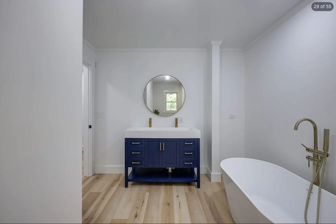 Bathroom with a navy vanity and bright white walls