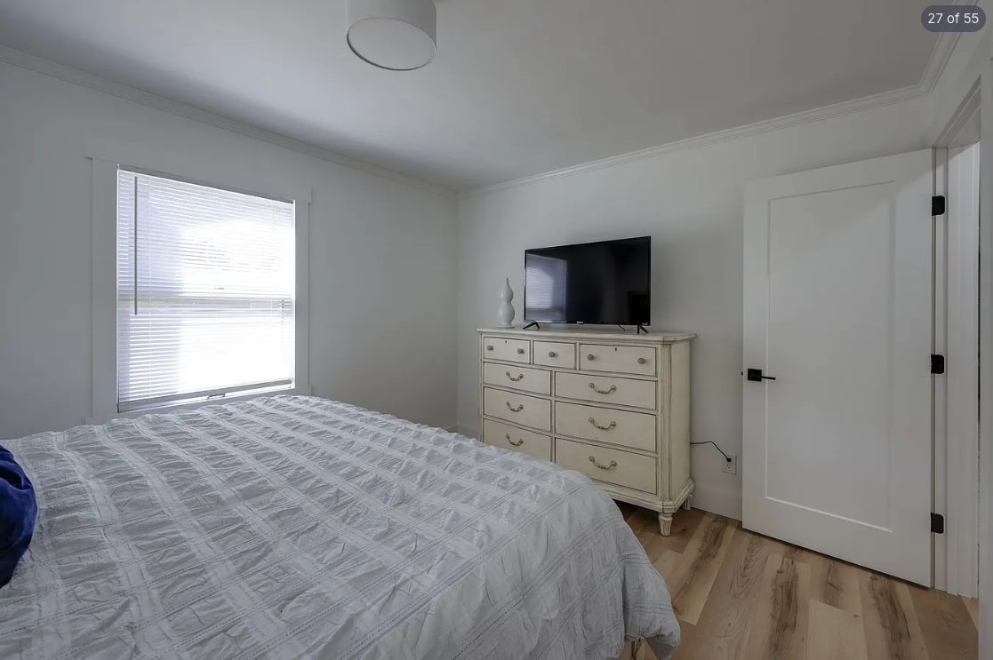 Bedroom with a wall-mounted TV and neutral painted walls