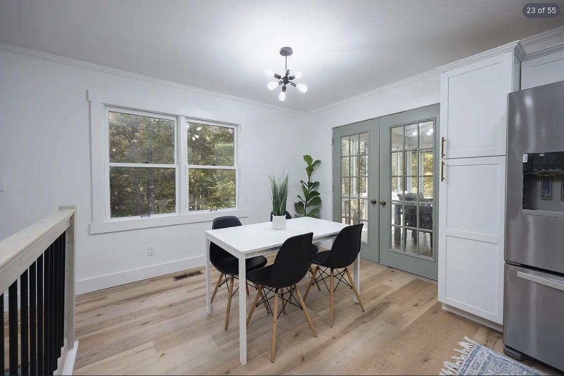 Dining area with white walls and sage green French doors